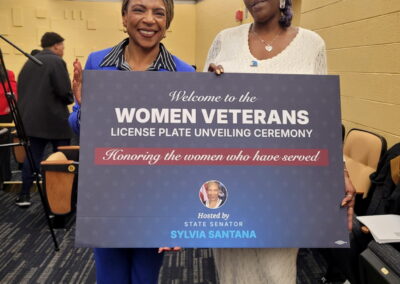 Image of Women Veterans in a group with a Michigan Women Veterans License Plate for a Vehicle.